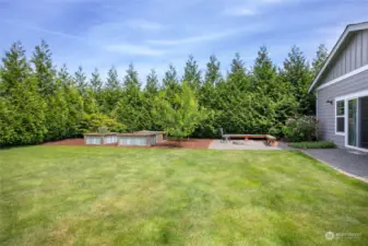 3 custom garden beds w/watering system & cozy firepit top off this private oasis