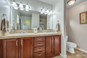 Primary bedroom bath featuring double sinks & linen closet.