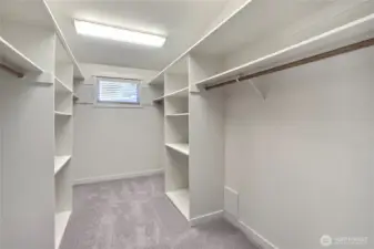 Beautiful, larger primary walk-in closet with built-in shelving.