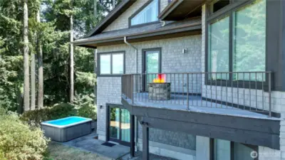 Rear view 1 of the home, 3 levels of living! Deck/porch/balcony off of the family room and main floor bedroom, lower level showing patio doors from rec room leading to patio and included hot tub.