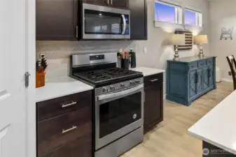 Well- maintained Palomino Home open concept chef's kitchen with quartz counters, Stainless steel appliances and soft-close cabinetry/great room/dining area