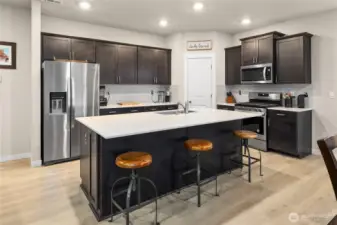 Well- maintained Palomino Home open concept chef's kitchen with quartz counters, Stainless steel appliances and soft-close cabinetry/great room/dining area