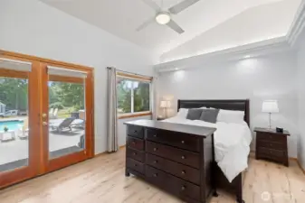 Large Primary suite with en-suite bathroom, walk in closet and large doors to the covered patio by the pool and hot tub.