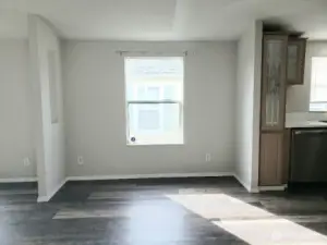 Picture of Dining Room between Kitchen and Second Living Room Showing Vinyl Plank Flooring and Newer Paint and Trim.