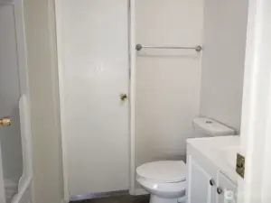 A View of the Main Guest Bathroom with Newer Sink Vanity, Toilet, Newer Trim, and Vinyl Plank Flooring.