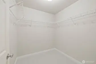Primary walk in closet with good shelving and lots of space.