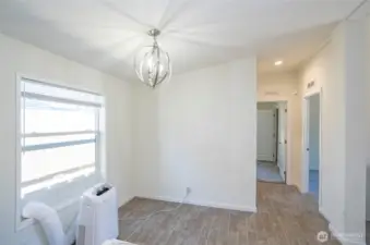 Dining area with a view down the hallway leading to the guest suites and full guest bath, all accented by beautiful laminate flooring.