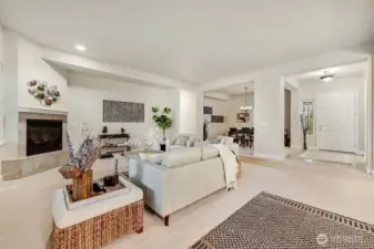 A cozy fireplace anchors the inviting living room, perfectly open to the kitchen for effortless entertaining.