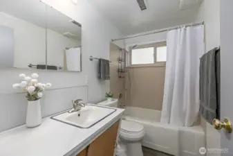 Full bath with mid-century vanity, new paint and flooring.