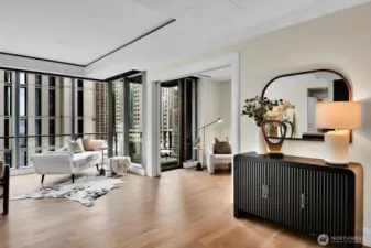 Floor to ceiling windows and gleaming hardwood floors provide a welcome entry to this residence.