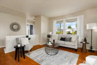 The living room feels bright and airy, with tall ceilings and large windows that bring in natural light throughout the day.