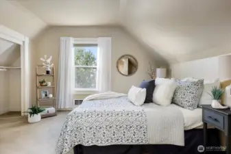 The primary bedroom offers a serene retreat with soft textures, natural light, and the quiet charm of the upper level.