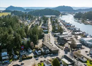 A sweeping aerial view reveals the iconic Rainbow Bridge, the marina, and the winding channel that give La Conner its unmistakable waterfront character.