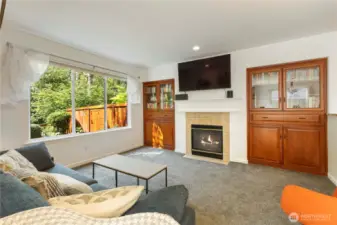 Living space with cozy gas fireplace looks out to beautiful backyard and greenbelt.