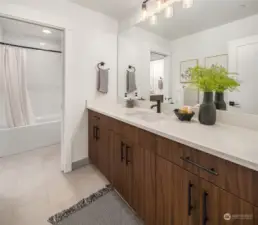 Quartz countertops with 4" quartz backsplash and tile shower.