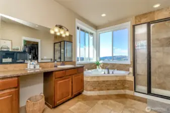 Spa like 5-piece primary bathroom features an expansive corner tub and beautifully tiled throughout