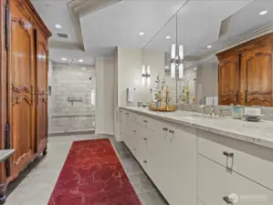 Primary bathroom with large walk in closet. Owner's antique armoire is in front of a large linen closet.