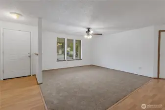 Bright and welcoming living room with large windows and ceiling fan