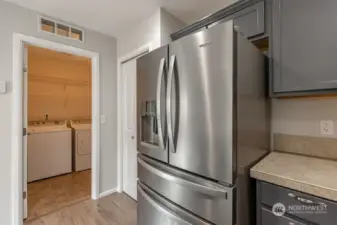 Off the kitchen is the laundry room with shelving.