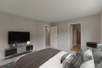 Staged. Spacious primary bedroom has an en suite bath and a walk-in closet.