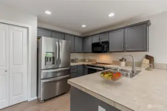 Staged. The kitchen features beautiful cabinetry and a pantry for extra storage.