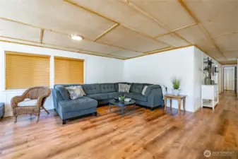Newer laminate flooring, wood paneled ceiling.