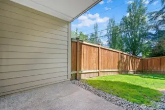Patio is adjacent to community yard and provides direct access to unit through glass paneled door