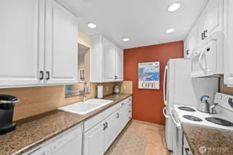 Kitchen with designer cabinets, tile backsplash and floor, dishwasher