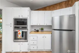 Showing the built-in oven/microwave and fridge.