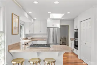 Well-appointed kitchen with double ovens, pantry storage, and a coffee/wine station highlighted by glass-front cabinets.