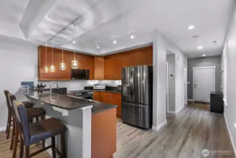 Modern kitchen with granite counters, stainless appliances, pendant lighting, and generous cabinet space.