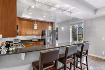 Extended breakfast bar with pendant lighting and granite counters.