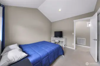 Another view of the upper bedroom highlighting the generous layout.