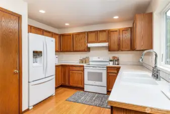 Kitchen with pantry offers abundant storage for cooking supplies and gadgets. Features a new 2025 refrigerator and warm bamboo floors.