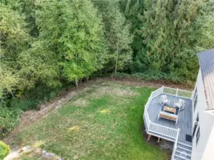 Private backyard featuring a spacious deck, open grassy area, and rare wrap-around greenbelt on two sides, offering exceptional privacy, serene views, and plenty of space to enjoy the outdoors.