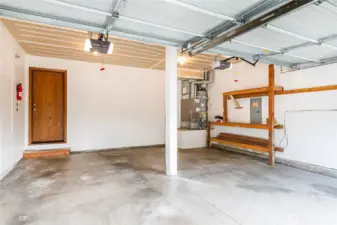 Squeaky clean garage with shelving for garden tools, storage bins, and other essentials.