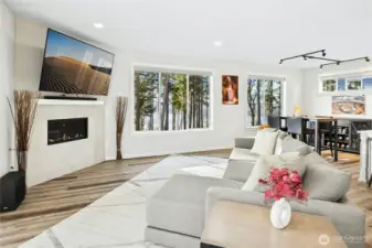 The open-concept living, dining, and kitchen areas are filled with natural light and showcase incredible views of Liberty Bay and the Olympic Mountains. Designed for both everyday living and entertaining, this space seamlessly blends modern comfort with breathtaking Northwest scenery.