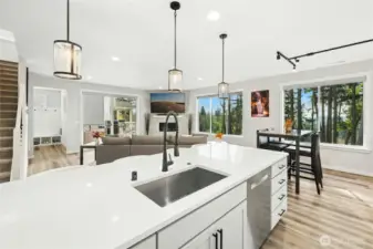 A large kitchen island anchors the space, offering the perfect gathering spot for entertaining and everyday living. With generous prep space and seating, it seamlessly connects the kitchen to the living and dining areas.