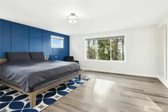The primary bedroom is a peaceful retreat featuring an updated accent wall and abundant natural light. A peekaboo view of the top of Mount Rainier adds a special Northwest touch to this serene space.