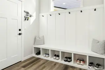The entrance off the garage on the firsrt level features a bright, well-designed mudroom with built-in bench seating, cubbies, and wall hooks for effortless everyday organization. Clean lines and thoughtful storage make this space both functional and inviting.