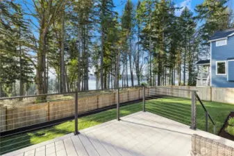 This elevated deck captures beautiful, filtered water views framed by towering evergreens, creating a serene and private outdoor setting. With modern cable railing and low-maintenance decking, it’s an ideal spot for dining al fresco, relaxing with a book, or entertaining while enjoying the peaceful Northwest backdrop and glimpses of the water beyond.