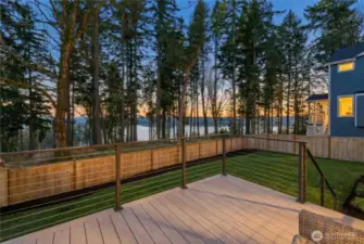 At sunset, the deck transforms into something truly special—golden light filtering through the evergreens with tranquil water views beyond. This peaceful outdoor space offers a front-row seat to Northwest evenings, where you can unwind, entertain, or simply take in the changing colors of the sky framed by trees and water. A perfect blend of privacy, nature, and ambiance.
