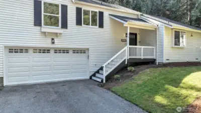 Features a new garage door with quiet belt drive and a charming covered front porch.