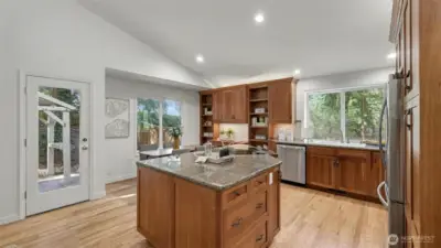 Granite topped island features an abundance of storage and new cooktop/oven.