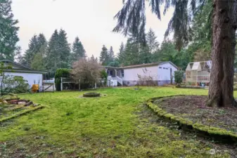 Side yard with fire pit and garden shed.