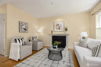 Enter to a cozy living room with wood-burning fireplace and bamboo floors