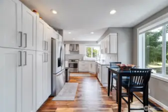 This light-filled kitchen features a cozy eating nook and abundant custom cabinetry for easy storage