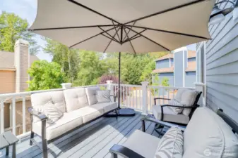 Located just off the main floor kitchen and informal living room, this elevated deck offers a refined, comfortable space for outdoor lounging and entertaining, with top-end decking and peaceful green surroundings