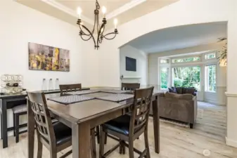 Formal dining room features a tray ceiling and arched doorways. To the left you'll find the French doors leading out to the sunroom!