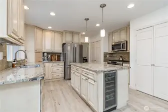 Well-appointed kitchen features granite counters, tiled backsplash, appliance garage and stainless steel appliances including a beverage fridge and a trash compactor!